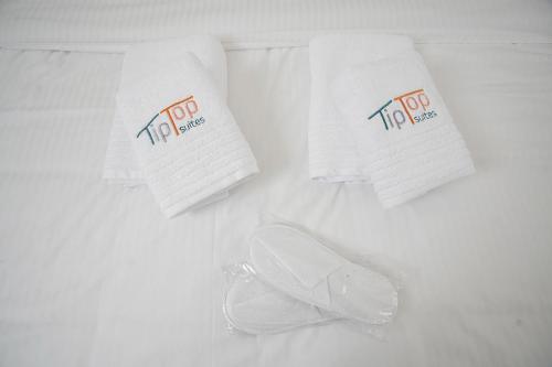 a group of towels and a pair of shoes on a bed at TiP - ToP Suites in Athens