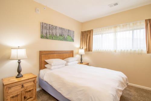 a bedroom with a white bed and a window at Coyote Mountain Lodge in Estes Park