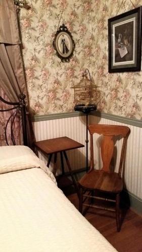 a bedroom with a bed and a chair and a clock at A Sentimental Journey in Gettysburg
