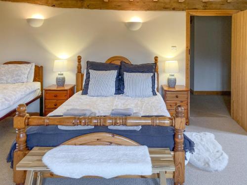 a bedroom with a wooden bed with two night stands at The Hop Pocket in Bromyard