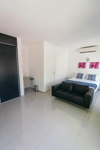 a black couch in a white room with a bed at Piscadera Harbour Village in Willemstad