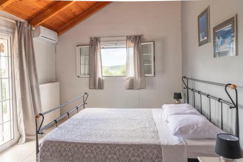 a bedroom with a bed and a window at Holiday House Zakynthos in Lithakia