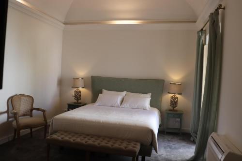 - une chambre avec un grand lit et une chaise dans l'établissement SOLAR DOS FRADES, à Ferreira do Alentejo