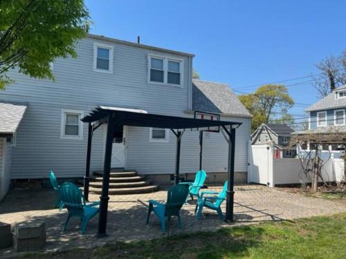 a pergola with blue chairs in a yard at Beautiful place minutes away to New York City . in Teaneck