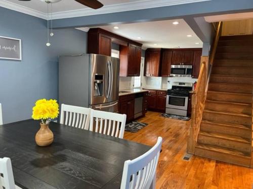 a kitchen with a table with chairs and a refrigerator at Beautiful place minutes away to New York City . in Teaneck
