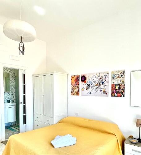 a bedroom with a yellow bed in a room at Bellevue Herculaneum B&B in Ercolano