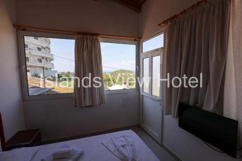 Islands View Hotel في كساميل: غرفة بها نافذة وسرير وطاولة