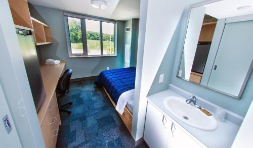 a bathroom with a sink and a mirror at Lakehead University Residence and Conference Centre in Orillia