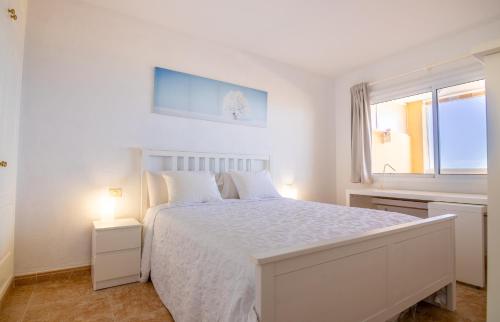 a white bedroom with a white bed and a window at Roque del Conde Seaview in Adeje