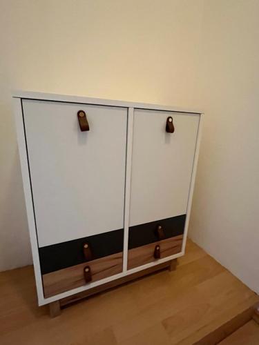a white cabinet with two doors in a room at Apartment Essen in Essen
