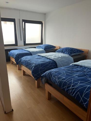 a row of four beds in a room at Apartment Essen in Essen