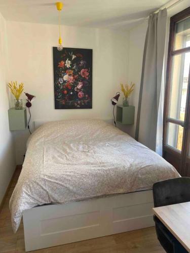 une chambre avec un lit avec un tableau sur le mur dans l'établissement Studio refait à neuf en hypercentre avec balcon, à Aix-les-Bains