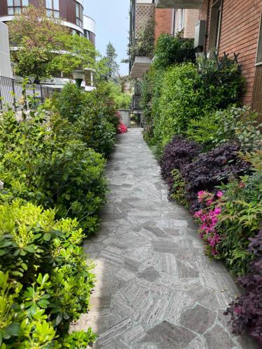 a stone path through a garden with flowers at Suite Luxury [Duomo - SanSiro] in Milan