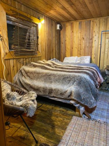 a bedroom with a bed in a wooden room at Karula Stay Sauna House at Karula National Park in Ähijärve