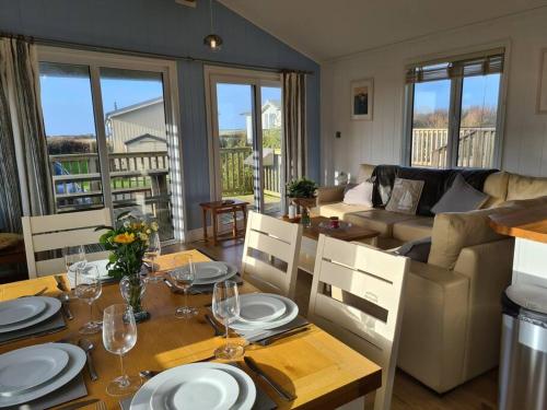a living room with a table and a couch at 3 Bedroom Lodge with Sea Views -Salcombe Retreat in Soar