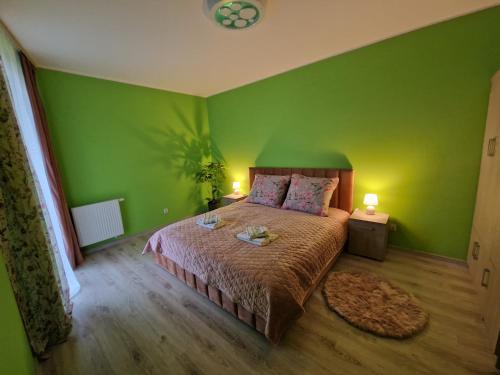 ein grünes Schlafzimmer mit einem Bett und zwei Lampen in der Unterkunft Oasis in Danzig