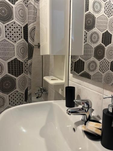 łazienka z białą umywalką i lustrem w obiekcie Joya apartament w mieście Tarent