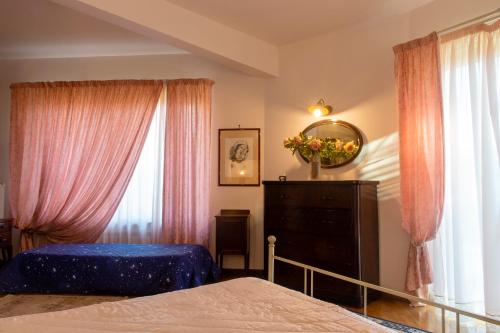um quarto com uma cama, uma cómoda e janelas em Green Village em San Giorgio a Liri