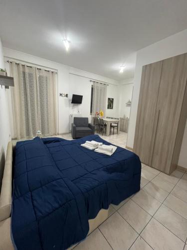 sypialnia z niebieskim łóżkiem i salon w obiekcie Joya apartament w mieście Tarent