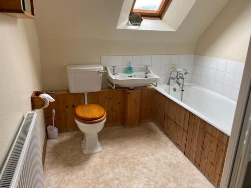 a bathroom with a toilet and a sink and a tub at Parkmore Holiday Cottages in Dufftown