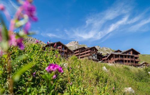 un groupe de bâtiments sur une colline avec des fleurs dans l'établissement Hôtel Village Montana by Les Etincelles, à Tignes
