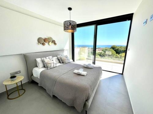 a bedroom with a bed and a large window at Apartamento Sukha Vistas al Mar in Gran Alacant