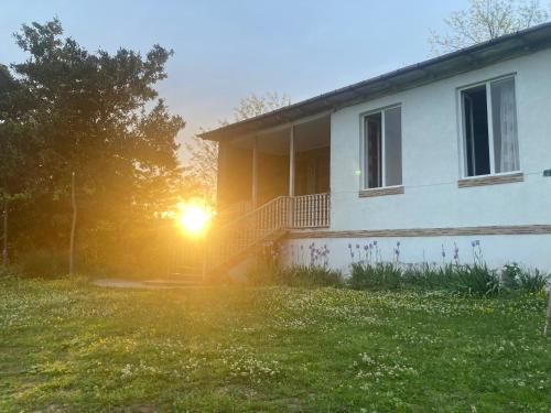a house with the sun setting behind it at Mira House in Martvili