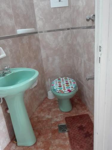 Un baño con un lavabo verde y un inodoro. en El mandala 2 depto centrico con cochera., en La Falda