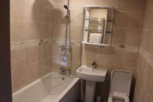 a bathroom with a sink and a toilet and a shower at Palmer's Ale House in Long Sutton