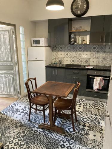 une cuisine avec une table en bois et deux chaises dans l'établissement Appartement centre historique, à Aix-en-Provence