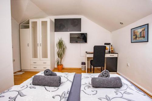 um quarto com uma cama, uma secretária e uma cadeira em Paris Night em Niš