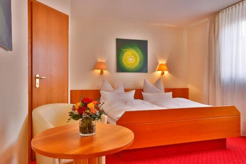 a hotel room with a bed and a table at Mayers Waldhorn - zwischen Reutlingen und Tübingen in Tübingen