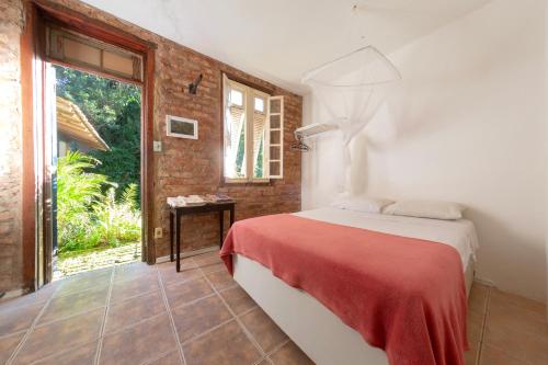 1 dormitorio con 1 cama en una habitación con ventana en Casa em meio a natureza - Ideal para casal, en Río de Janeiro