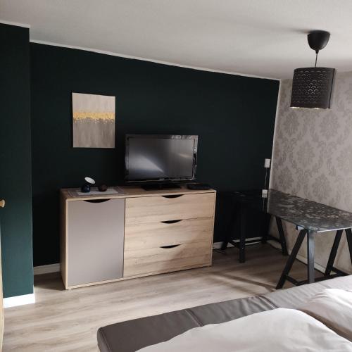 1 dormitorio con TV en una cómoda de madera en FeWo Altstadt BL, en Bad Laasphe
