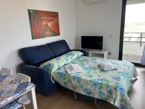 salon z kanapą i łóżkiem w obiekcie Panoramic Sport Apartment: vista golfo di Cagliari w Cagliari