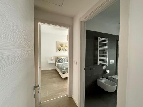- un couloir avec une salle de bains pourvue d'un lavabo et d'un miroir dans l'établissement Stupendo appartamento in Fiera Milano-Up Town, à Pero