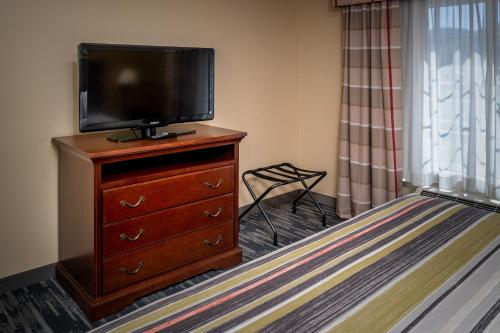 a bedroom with a television on a dresser with a bed at Country Inn & Suites By Radisson, Charleston South, WV in Charleston