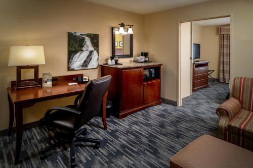 a hotel room with a desk and a chair at Country Inn & Suites By Radisson, Charleston South, WV in Charleston