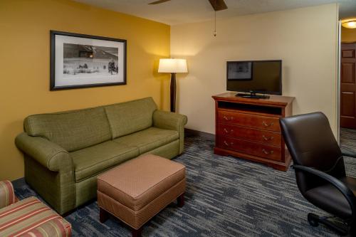 a living room with a couch and a television at Country Inn & Suites By Radisson, Charleston South, WV in Charleston