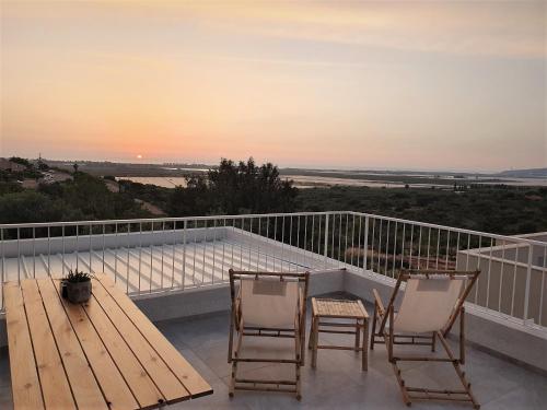 2 chaises et une table sur un balcon avec un coucher de soleil dans l'établissement Sea view, à Kabri