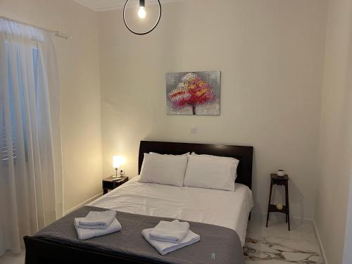 um quarto com uma cama com duas toalhas em Home in nature em Michalítsion