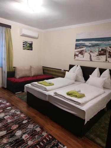 a bedroom with a bed and a couch at Arnika Vendégház in Hajdúszoboszló