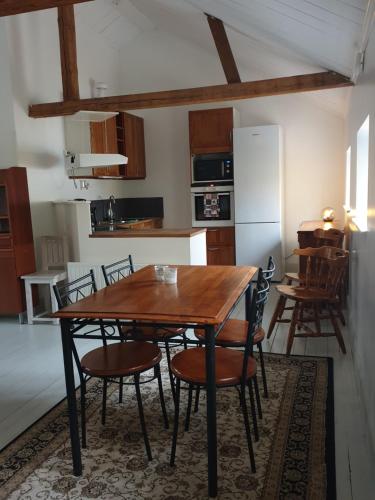 - une cuisine avec une table en bois et des chaises dans l'établissement Sönerna på Nordgrenska semesterboende 12B, à Åmål