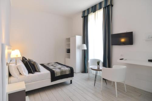 um quarto com uma cama, uma mesa e uma cadeira em Lata Luxury Rooms em Roma