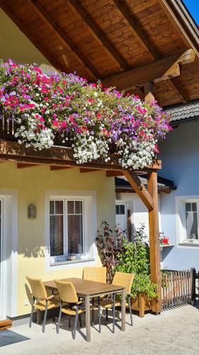 a wooden table with chairs and flowers on a building at Ferienhaus Pepi in Strobl