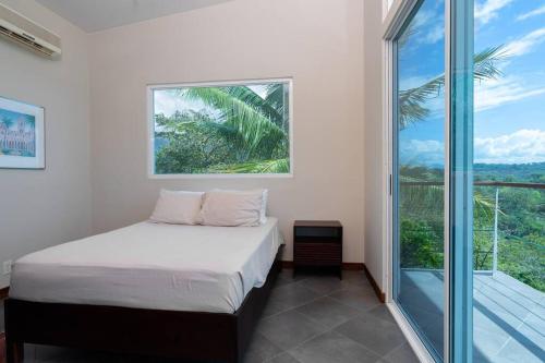 1 dormitorio con cama y ventana grande en Casa Sol w/ Ocean View & Pool, en Paquita