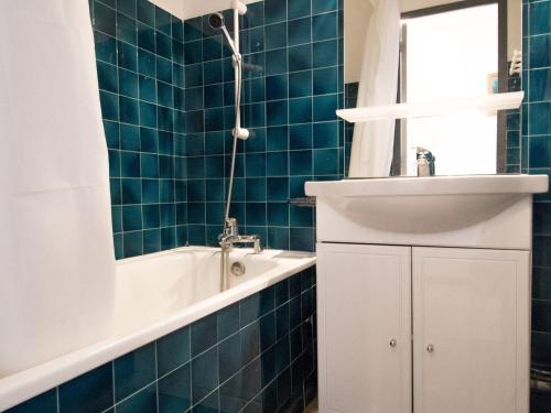 a blue tiled bathroom with a tub and a sink at Charmant appartement à 300m des pistes à Lanslebourg avec balcon et garage - FR-1-508-71 in Lanslebourg-Mont-Cenis