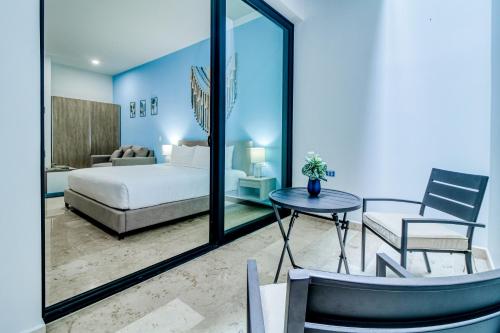 ein Schlafzimmer mit einem Bett, einem Tisch und einem Stuhl in der Unterkunft The Perfect Place, Unit 005 in Playa del Carmen