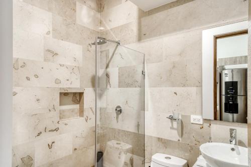 uma casa de banho com um chuveiro, um WC e um lavatório. em The Perfect Place, Unit 005 em Playa del Carmen