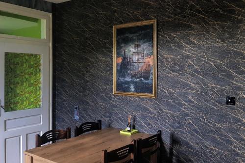 uma sala de jantar com uma mesa e uma imagem na parede em Дионея em Belogradchik